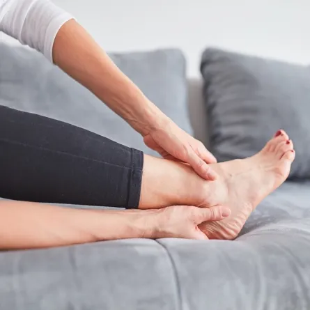 صورة لامرأة تمسك قدمها