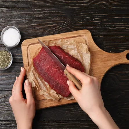 صورة لامرأة تقطع اللحم