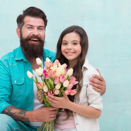 صورة لطفلة تقدم الورود لأبيها في يومه