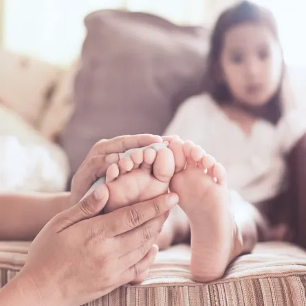 صورة لأم تمسك قدم طفلتها