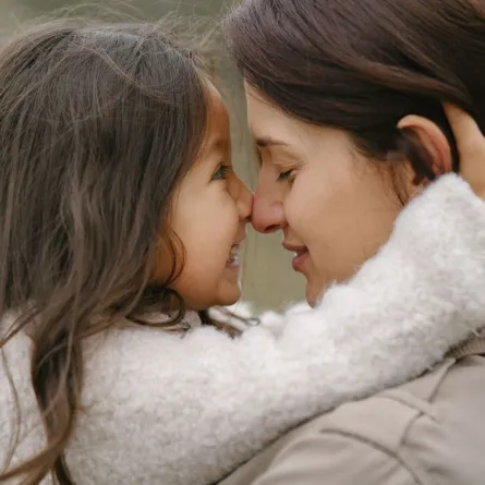 صورة أم تعانق طفلتها