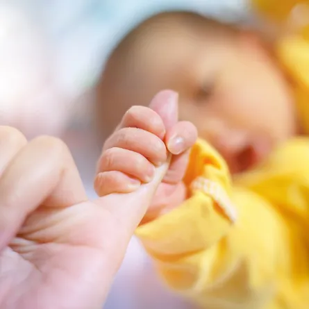 الصورة لرضيع يتمسك بأمه