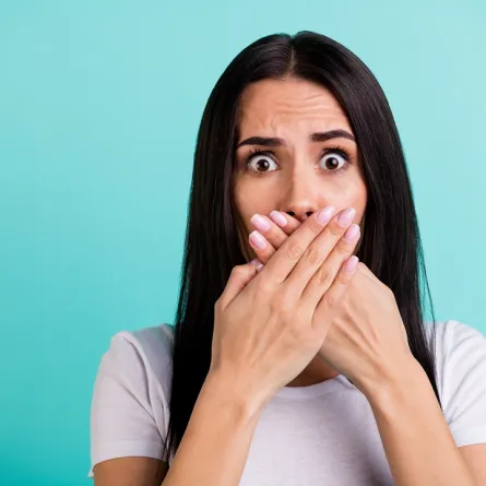 صورة لامرأة تضع يديها في فمها