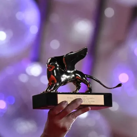 جائزة الأسد الذهبي تحملها المخرجة الأمريكية لورا بويتراس (US director Laura Poitras holds the Golden Lion for Best Film). مصدر الصورة: Tiziana FABI / AFP