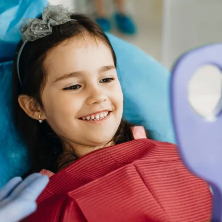 صورة لطفلة سعيدة بجمال أسنانها