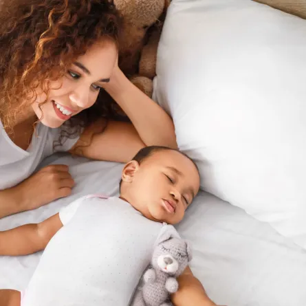 صورة لأم تهمس لطفلها أثناء نومه