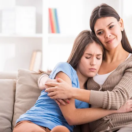 صورة لأم تحضن ابنتها المراهقة