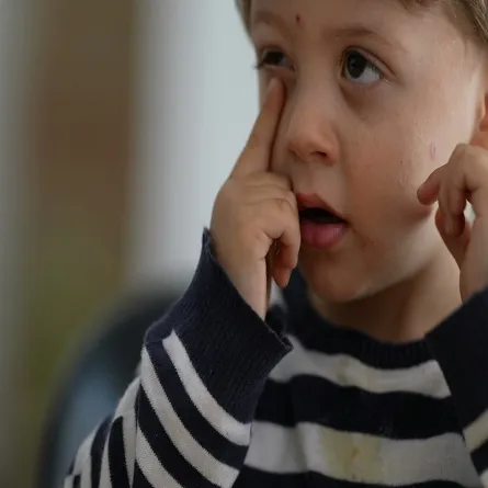 صورة لطفل يضع يديه علي عينيه