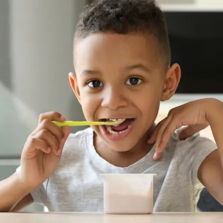 صورة لطفل يستمتع بتناول اللبن الزبادي