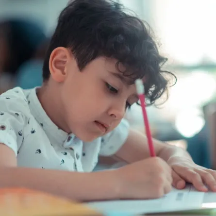 صورة لطفل يقرأ ويكتب في نفس الوقت