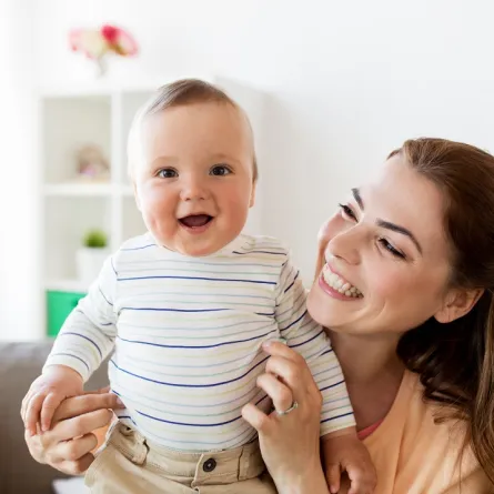 صورة لطفل سعيد تحمله أمه