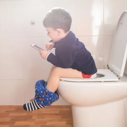 صورة طفل يجلس على المرحاض