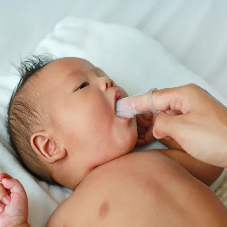 صورة لأم تنظف فم طفلها الرضيع