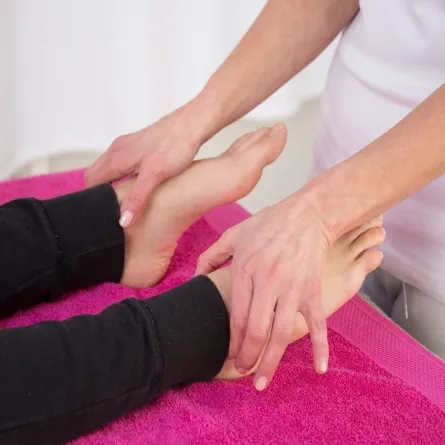 صورة لإخصائية تقوم بتدليك قدم امرأة