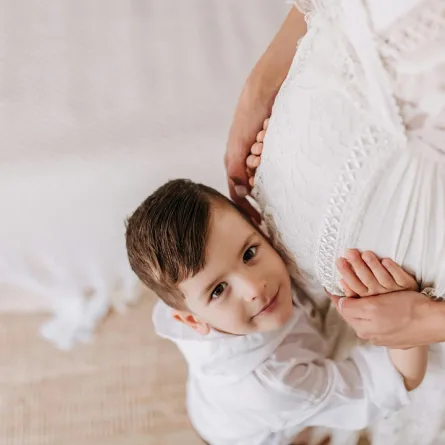 صورة لطفل يحتضن بطن أمه