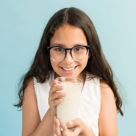 صورة لطفلة تحمل كوباً من الحليب