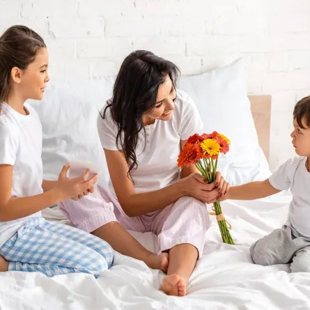 صورة لطفل يقدم زهوراً لوالدته