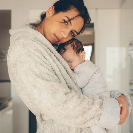 صورة لرضيع يحتمي بحضن أمه