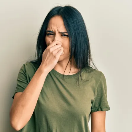 صورة لامرأة تضع يديها على أنفها