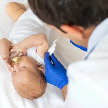 صورة لطبيب يعطى طفلاً رضيعاً حقنة