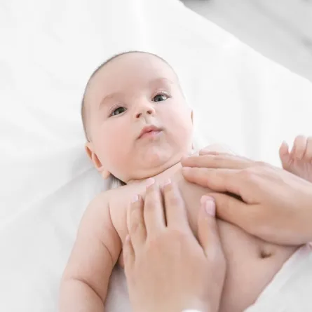 صورة لأم تقوم بتدليك طفلها الرضيع