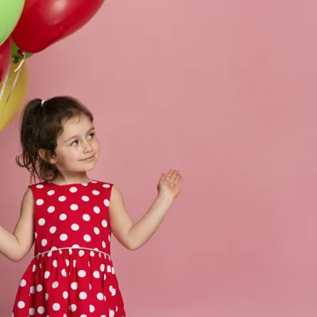 صورة لطفلة تحمل بالونات