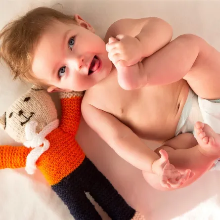 صورة لطفل فرح باكتشاف يديه وقدميه