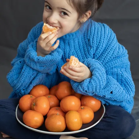 صورة لطفلة تتناول اليوسفي