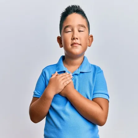 صورة لطفل يضع يديه على قلبه