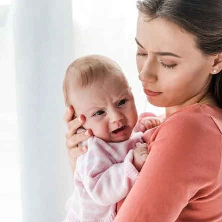 صورة لأم تمسك برأس رضيعها