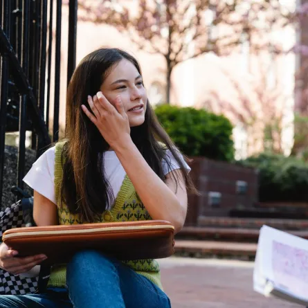 طالبة تجلس على سلالم الجامعة