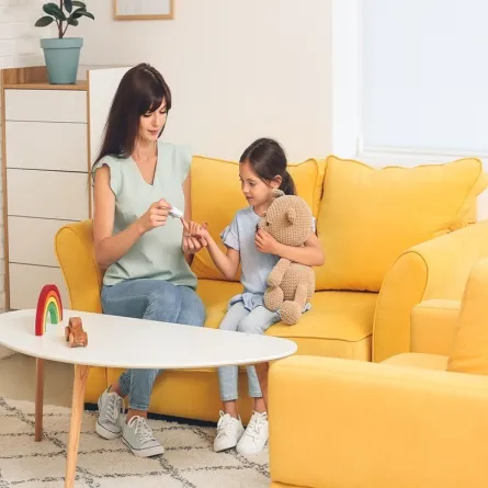 صورة لأم تجري اختبار سكري لابنتها