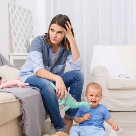 صورة لأم في حالة من القلق بسبب بكاء طفلها