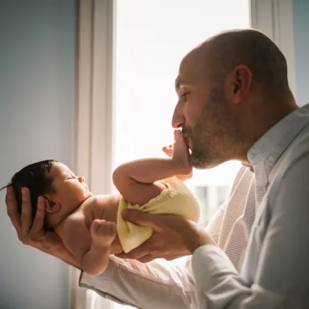 صورة أب يقبل رجلي طفله