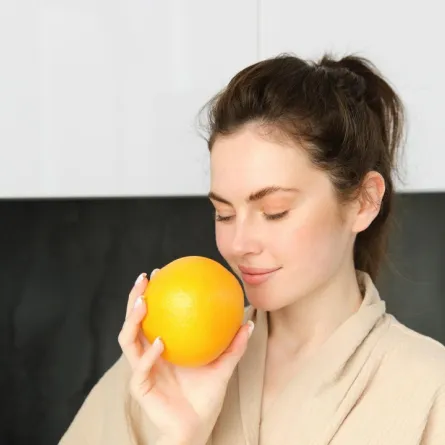 صورة لحامل تمسك ببرتقالة