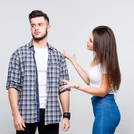 زوجان متخاصمان يبدو عليهما الشقاق وهما جالسان على السرير بحجرة نومهما