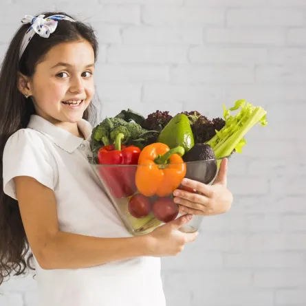 صورة لفتاة تحمل خضروات