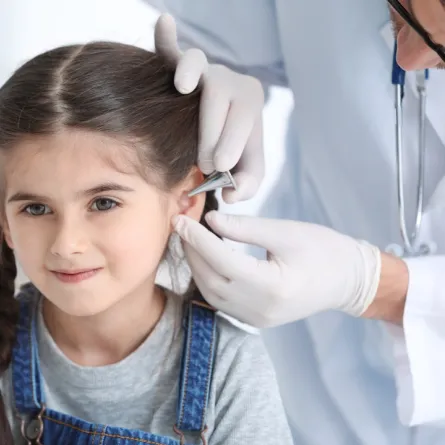 صورة لطبيب يفحص أذن طفل