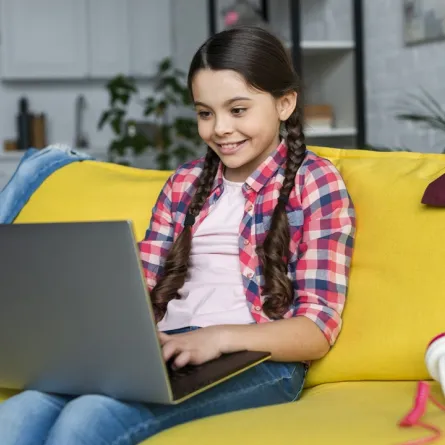 صورة لطفلة تجلس أمام اللابتوب