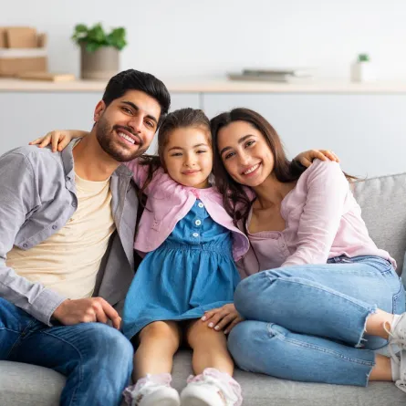 صورة لطفلة تحتضن والديها