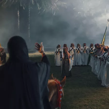 مشهد من العمل يصور الشاعرة مع مؤدي العرضة - مصدر الصورة شركة تراكيب 