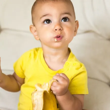 صورة طفل يأكل الموز