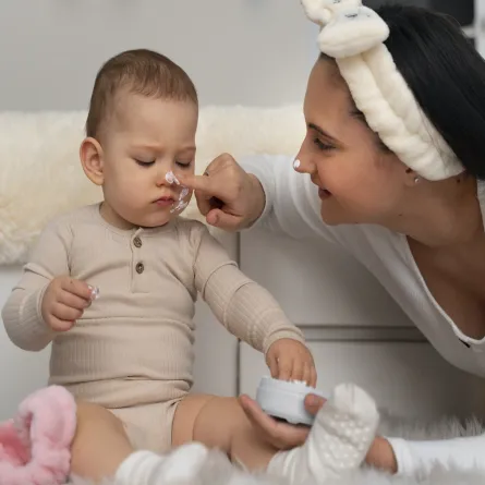 أم تضع لرضيعها كريم ترطيب على الوجه لعلاج الجفاف