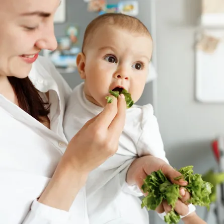 صورة لأم تطعم طفلها الطعام المفيد