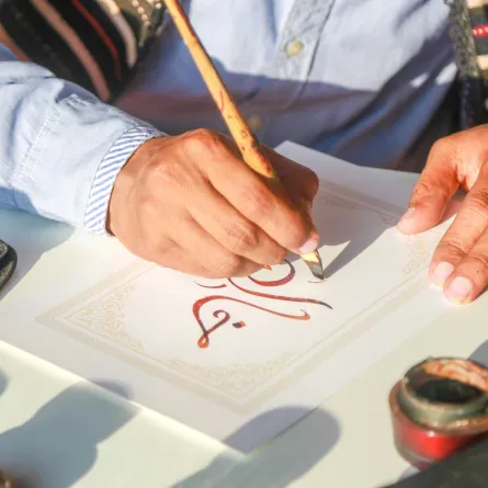 شاعر يخط بقلمه كلمات جميلة بالخد النسخ