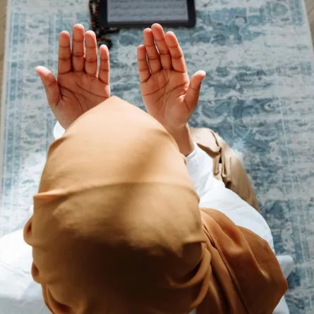 فتاة ترفع يدها بالدعاء لله سبحانه وتعالى