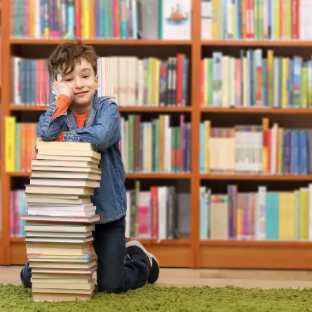 صورة تعبيرية لطفل يبحث بين الكتب