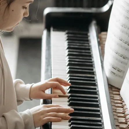 عازفة تعزف على البيانو من خلال النوتة الموسيقية