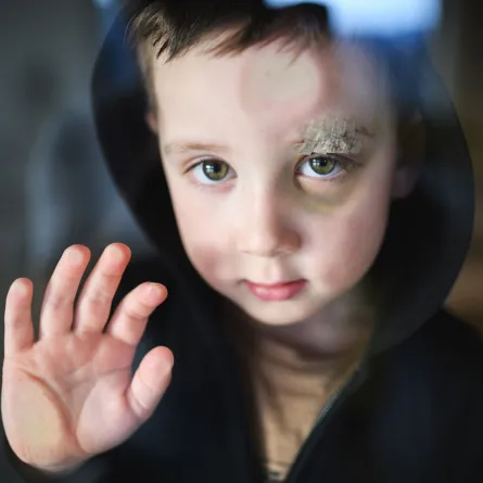 صورة طفل يضع يده على الزجاج