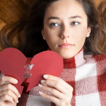 امرأة شابة تحمل شكل قلب مكسور